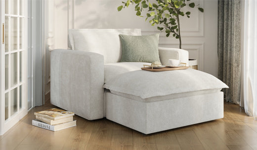 A modern light gray sectional sofa with a chaise lounge portion, decorated with throw pillows.