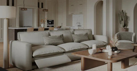 A stylish living room featuring a contemporary sofa in a light shade, adorned with patterned cushions.