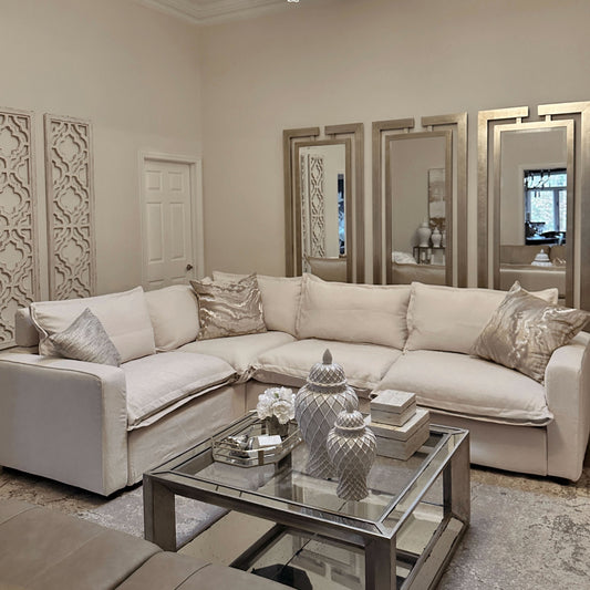 Modern living room with a plush white L-shaped sectional sofa featuring metallic accent pillows