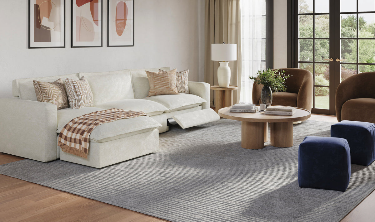 Modern living room with plush white sectional, neutral tones, and geometric wall art creating serene atmosphere.